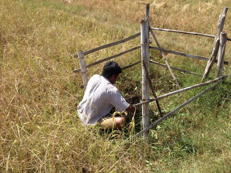 Poverty Reduction - A man sits in front the pond